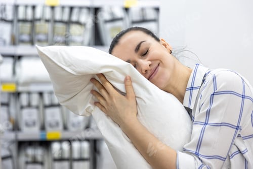 Preview: A young woman chooses a pillow in a home improvement store.