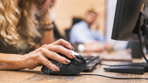 Preview: Crop mature businesswoman using computer mouse on desk in office