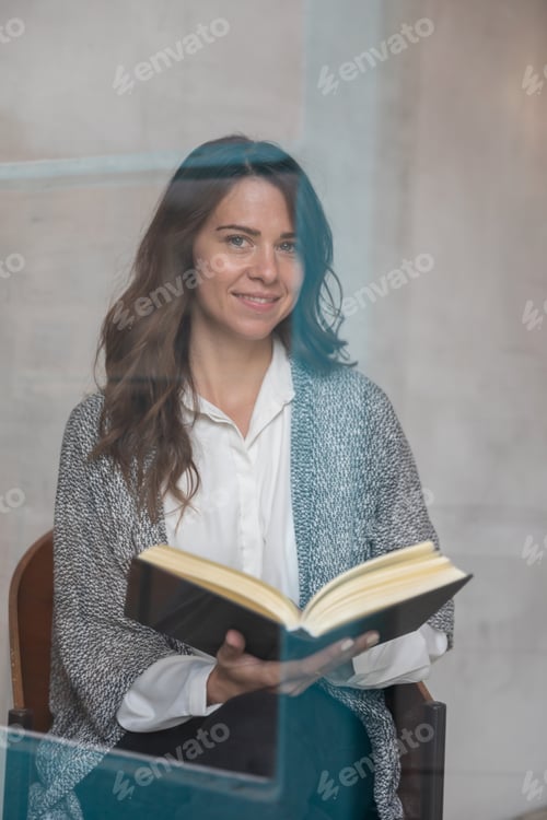 Preview: Young girl reading a book at home