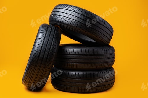 Preview: Car tires isolated on yellow background, close up