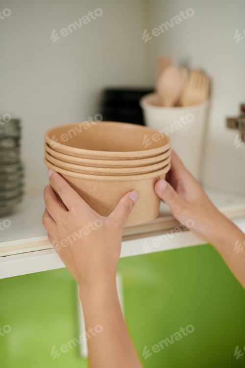 Preview: Woman Putting Disposable Bowls on Shelf