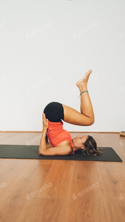 Preview: Mid-age woman practicing yoga in a yoga studio