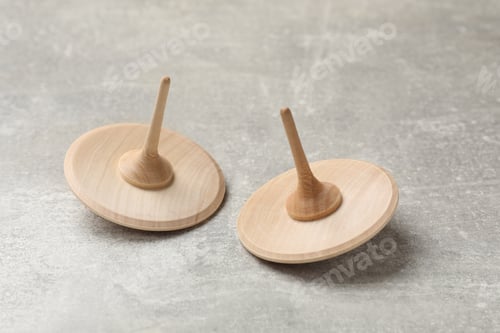 Preview: Wooden spinning tops on grey textured background, closeup