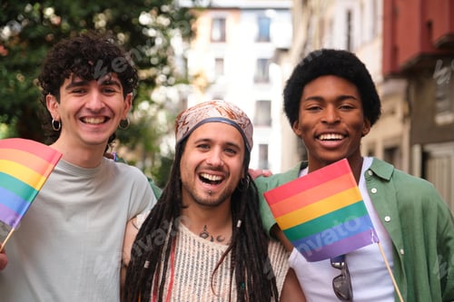 Preview: Happy multi ethnic friends celebrating gay pride holding rainbow flags