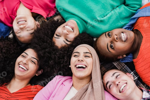 Preview: Multiracial women lying and smiling at city park - Beautiful diverse female friends enjoy day