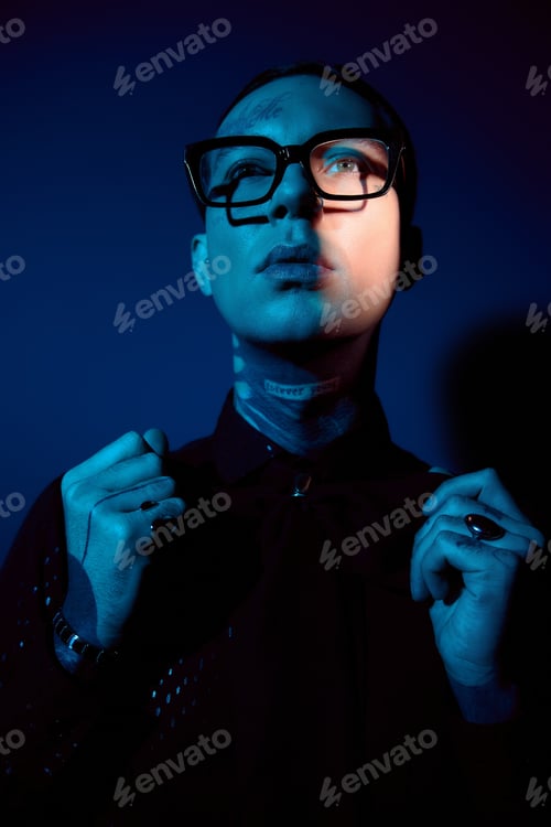 Preview: Handsome man dressed in stylish attire showcasing modern fashion in a creative lighting setup