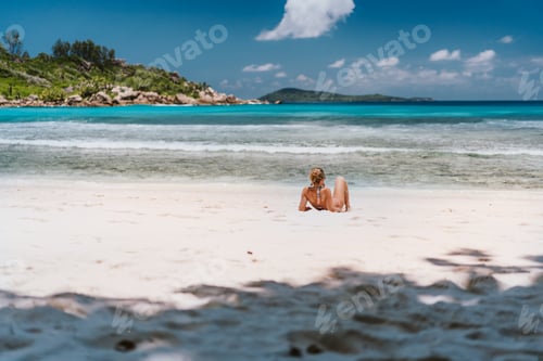Preview: Young tanned woman enjoying tropical sandy beach Anse Cocos at La Digue Island, Seychelles