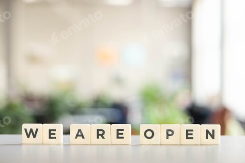 Preview: white cubes with we are open lettering on white desk in office