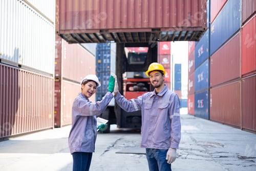 Preview: Engineers shaking hands congratulating themselves on success with shipping containers
