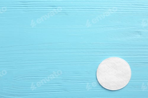 Preview: Cotton pad on wooden background, top view. Space for text