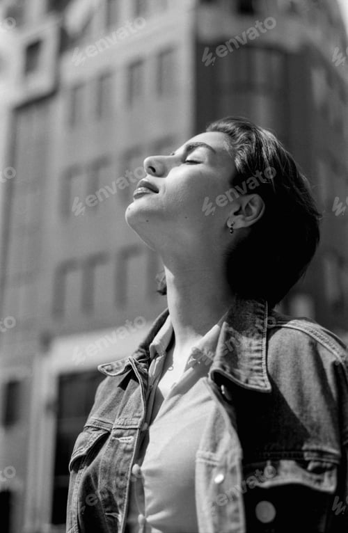 Preview: Young woman breathing fresh air in urban setting, grainy analog photo