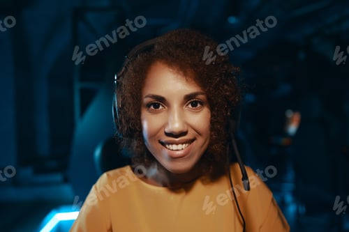 Preview: Young curly woman in headphones.
