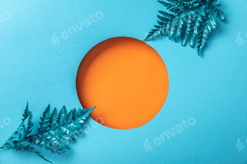 Preview: blue decorative fern leaves near orange hole on blue paper