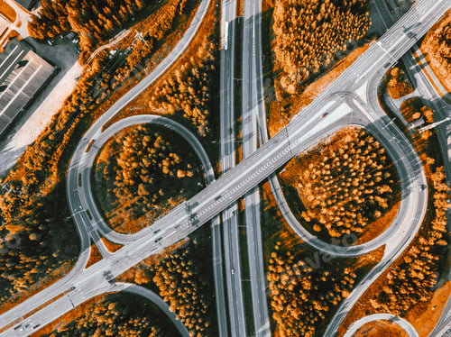 Preview: Aerial view of highway and overpass with autumn color woods on a fall day in Finland.