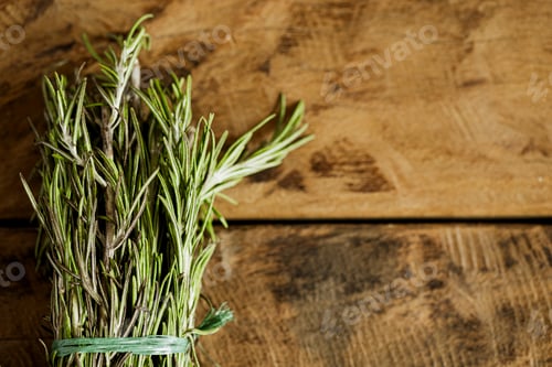 Preview: bunch of rosemary leaves on a wooden surface