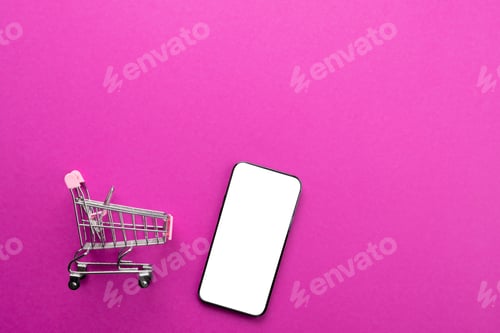 Preview: Composition of shopping cart and smartphone with copy space on pink background