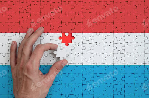 Preview: Luxembourg flag is depicted on a puzzle, which the man's hand completes to fold.