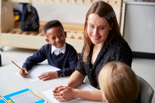 Preview: Elevated view of a female primary school teacher sitting between two school kids