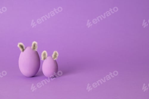 Preview: Easter eggs on a purple background with copy space. Side view mockup template. egg with ears