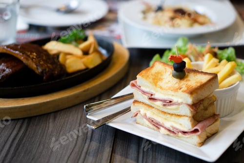 Vorschau: Close-up of sandwich ham cheese served with BBQ Pork Ribs and pasta cheese on table.