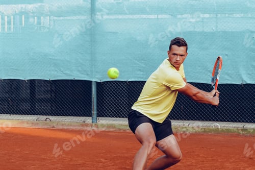 Preview: Young handsome man playing tennis on the tennis court