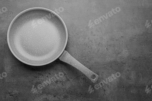 Preview: New non-stick frying pan on grey table, top view. Space for text