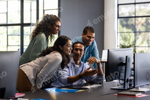 Preview: Collaborating in office, diverse team discussing project ideas around computer