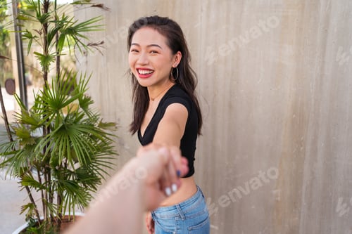 Preview: Smiling ethnic woman holding hands with friend
