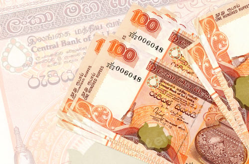 Preview: 100 Sri Lankan rupees bills lies in stack on background of big semi-transparent banknote. Abstract