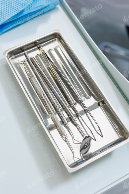 Preview: Tray with metal dental tools. Tools of the dentist. Interior of a patient reception room