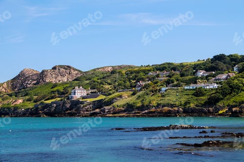 Preview: Howth Dublin beach view with the clean sea and forested, green mountains, blue sky background
