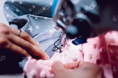 Preview: Seamstress dressmaker working with sewing machine in workshop