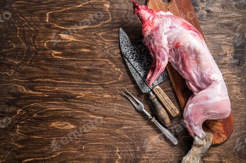 Preview: Whole game hare, raw meat on wooden old rustic table. Wooden background. Top view. Copy space