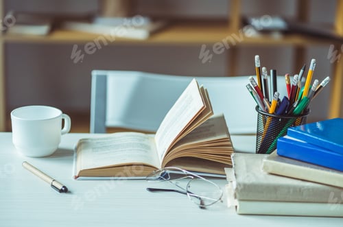 Preview: close-up view of books, eyeglasses and coffee cup on table