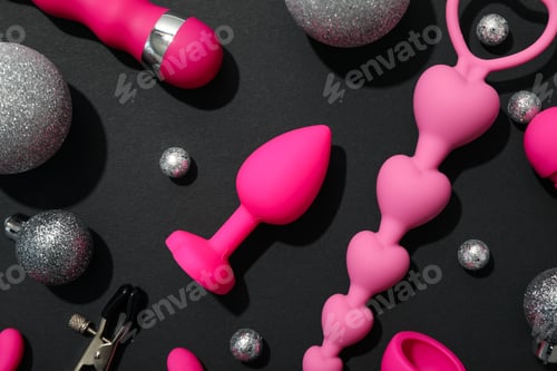 Preview: Sex toys with Christmas decorations on a dark background.