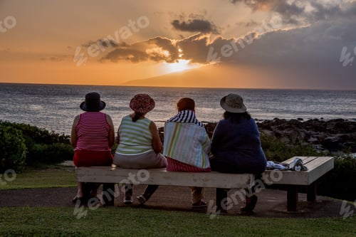 Preview: Four women friends watch as the sun sets in Maui Hawaii