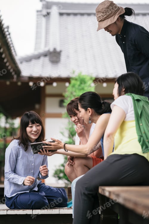 Preview: Group of japanese tourists using a tablet