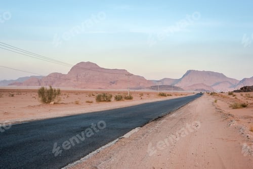 Preview: Desert road leading off into the distance at sunset, mountains, golden light