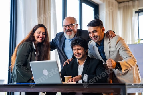 Preview: Group of Indian professionals in executive attire celebrate teamwork success with high five