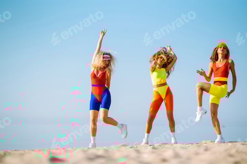 Preview: Smiling dancers in colorful swimsuits are dancing on beach ?oncept of sports, aerobics. Active sport