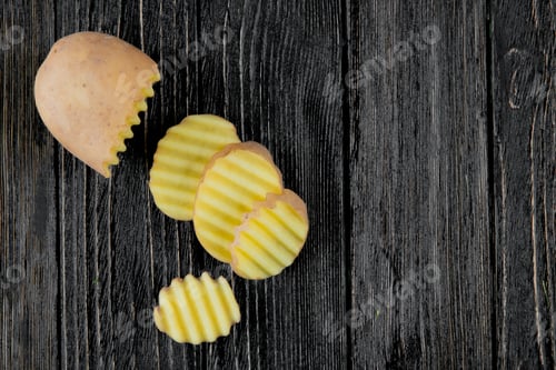 Preview: close-up view of cut and sliced potato slices on wooden background with copy space