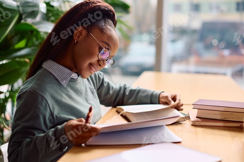 Preview: Happy black female student learning at the university.