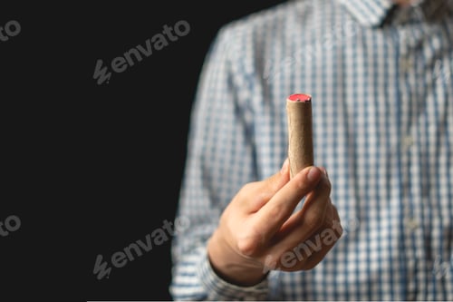 Preview: close up hand hold cracker and fire it on dark background isolated f