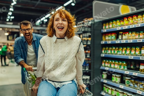 Preview: Happy couple having fun while grocery shopping in supermarket