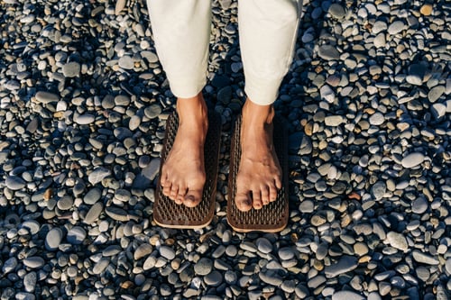 Preview: Close-up of female feet on boards with nails practice acupressure.