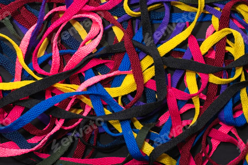 Preview: colorful shoelaces background, on black wood, messy, clutter concept, advertisement