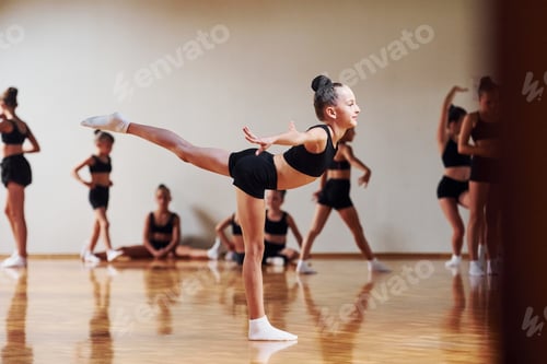 Preview: Group of female kids practicing athletic exercises together indoors