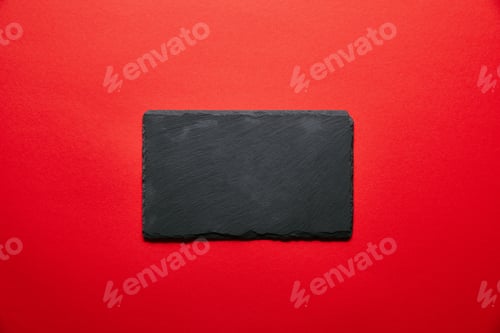 Preview: top view of empty black slate plate for sushi isolated on red