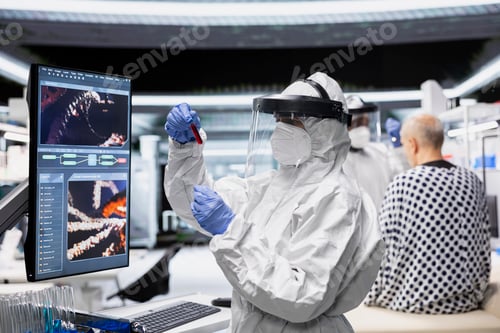 Preview: Expert in a protective suit studies immune response on infected patient