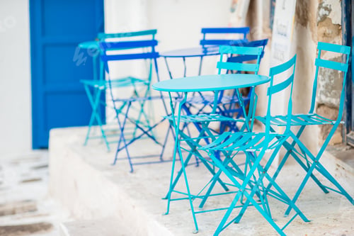 Preview: Outdoor cafe on a street of typical greek traditional village in Greece. Coffee on table for